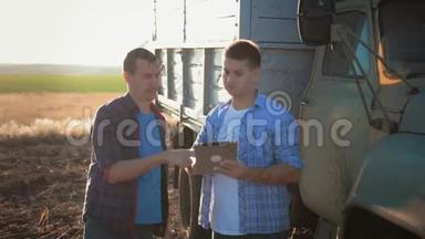 农户在麦地干活，沟通，看片.. 两个农民在田间交谈，用平板电脑。